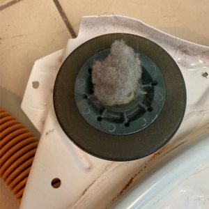 Dirty and damaged roller wheel from a dryer drum mechanism. Caption: Addressing a dirty, damaged roller wheel to restore dryer functionality.